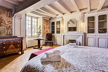 Chambre avec boiseries anciennes et cheminée au Château de Juvardeil
