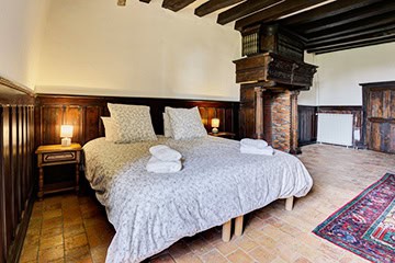 Chambre de caractère avec cheminée en bois et murs lambrissés au Château de Juvardeil en Anjou