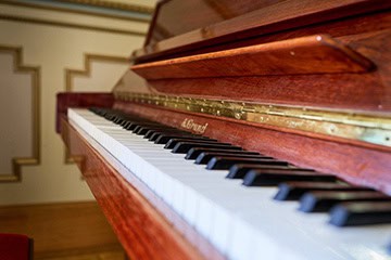 Piano ancien en bois dans un salon du Château de Juvardeil en Anjou